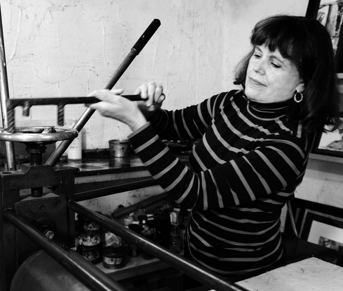 Imagen de una mujer manipulando una imprenta antigua