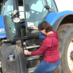 Foto de mujer subiendo a un tractor